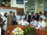 Ông Trương Tấn Sang (ngồi, bên trái) viết lưu bút tại Văn phòng Công ty Tân Đức